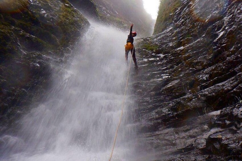 A person rappelling down a waterfall. 2
