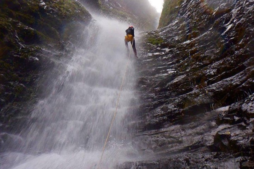A person rappelling down a waterfall. 4
