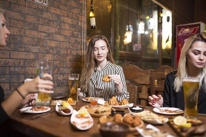 Un gruppo di persone che cena in un ristorante con pareti in mattoni e arredi in legno. 1