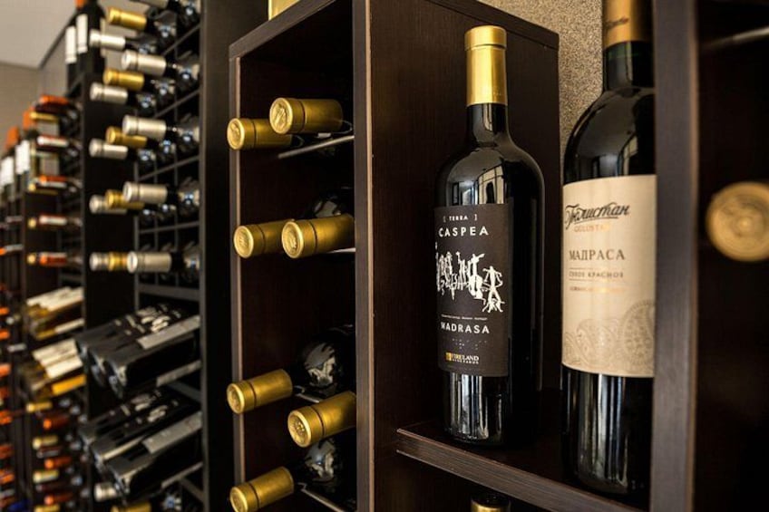 Una botellera con botellas, incluyendo un vino Caspian y un vino Manapa. 5