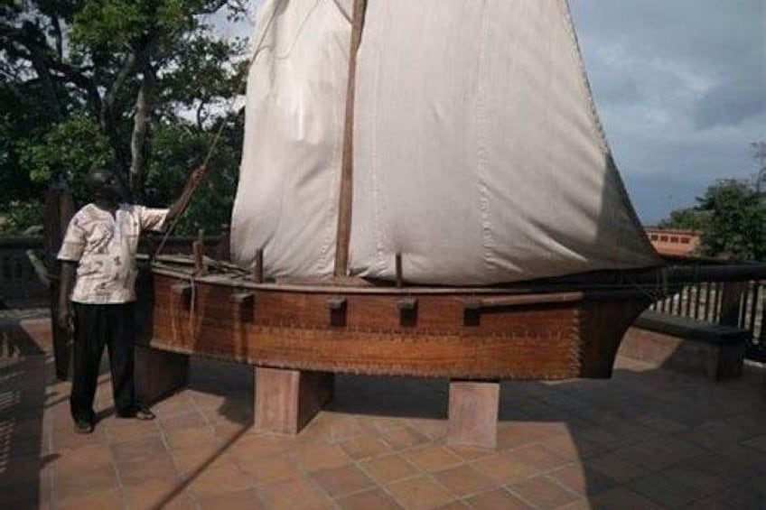 Ein Modellschiff ist ausgestellt, möglicherweise als historische oder pädagogische Ausstellung, mit einer Person daneben. 5