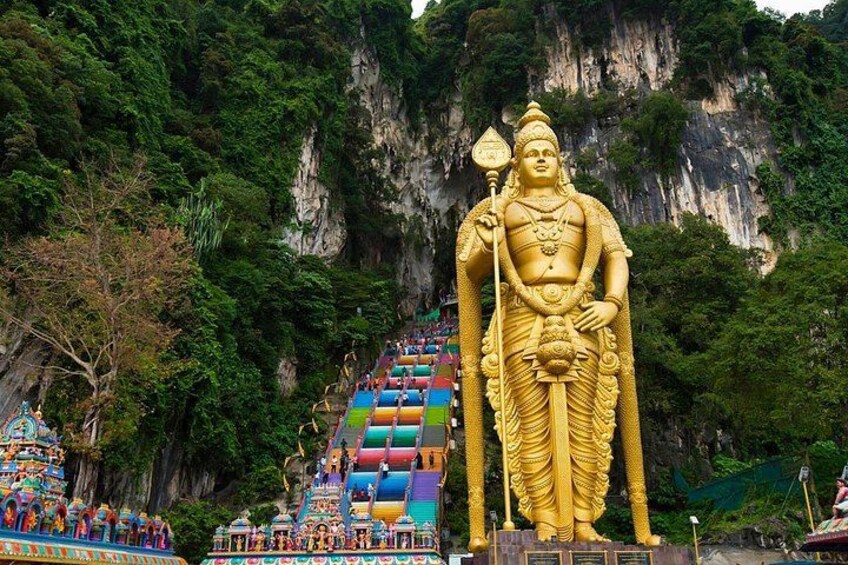 A large golden statue of a deity, a colorful staircase, and a mountainous backdrop. 3