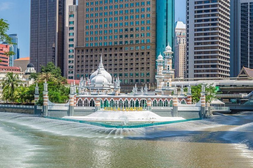 A mosque with a large dome and minarets, surrounded by a body of water and modern buildings in the background. 4