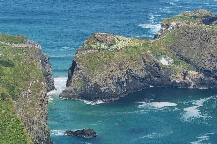 A rugged coastline with rocky cliffs and a small building on the shore. 2