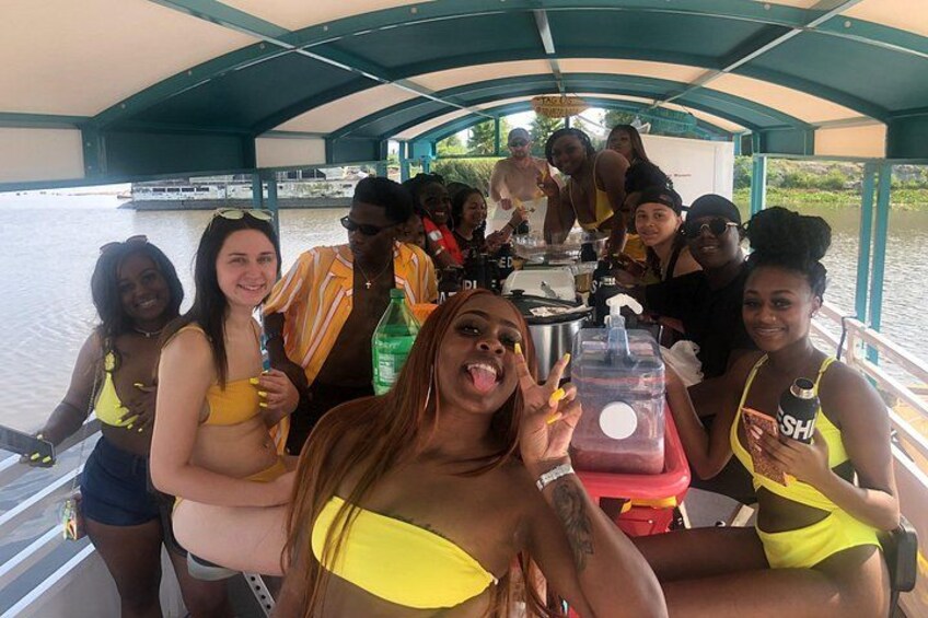 A group of people on a boat with a covered structure overhead. 5