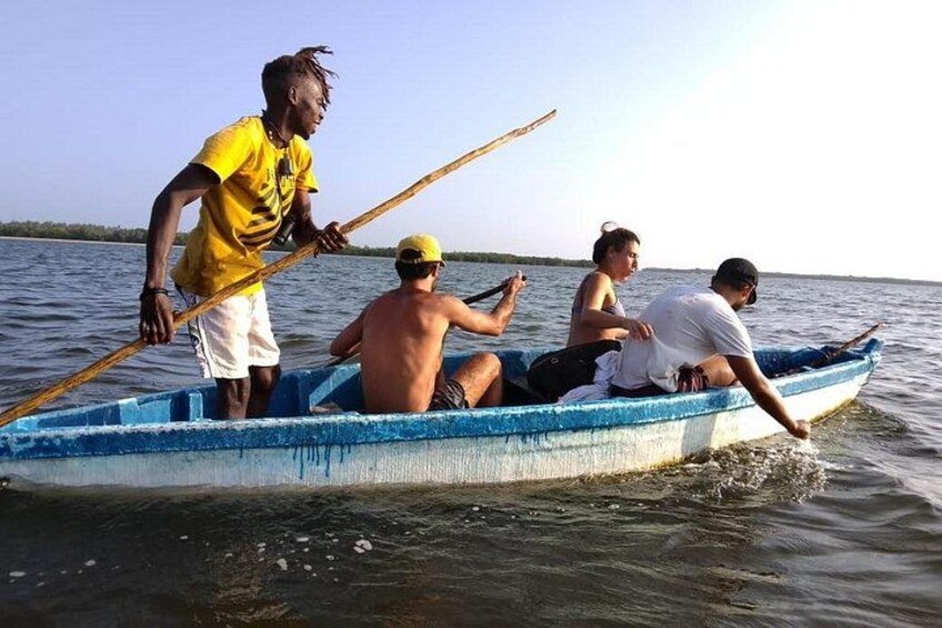 Un petit bateau avec quatre personnes à bord, naviguant sur une étendue d’eau calme. 2