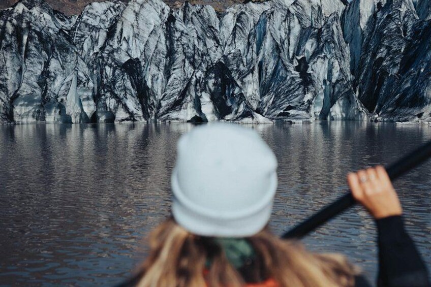 Una persona haciendo kayak en aguas tranquilas, con un glaciar al fondo. 3