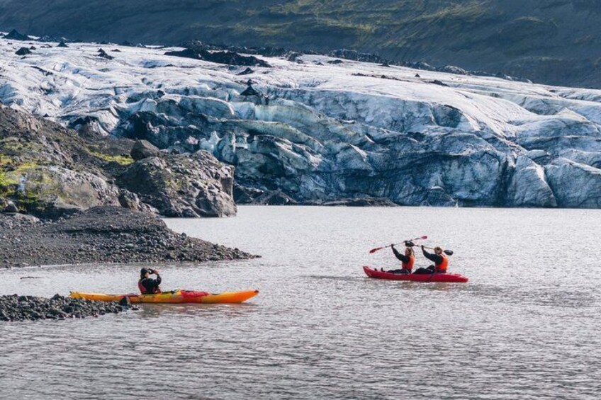 Dos kayakistas en aguas tranquilas con un glaciar al fondo. 4