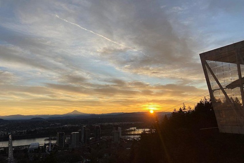 A sunset over a cityscape with a mountain in the background. 2