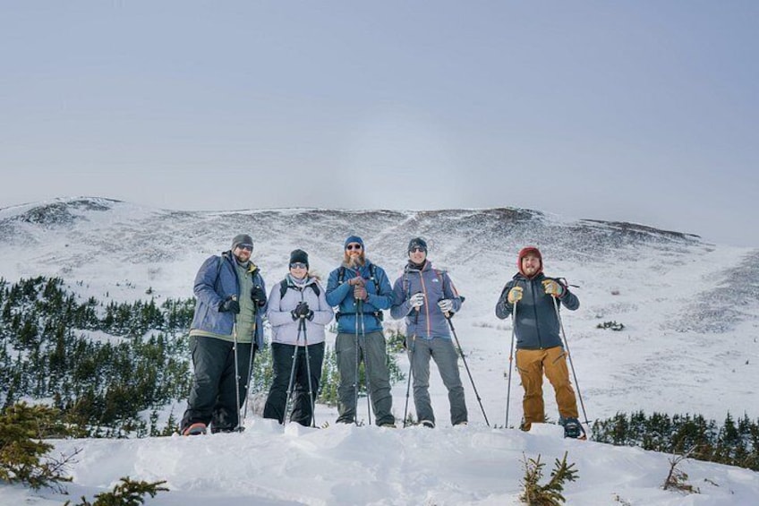 A group of people skiing on a snowy mountain with trees in the background. 5