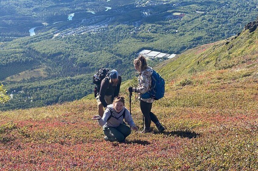 Two hikers on a grassy hillside with a valley in the background. 3