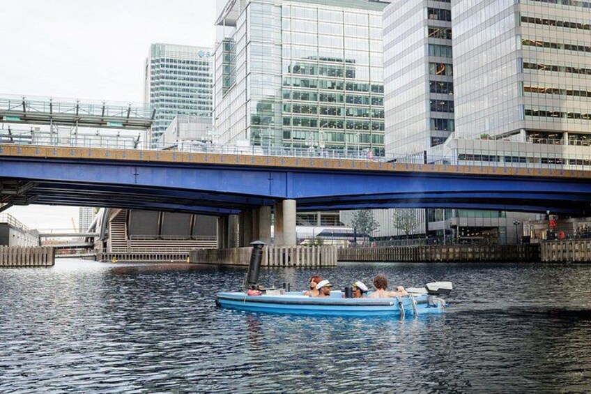 Una embarcación azul con gente en un río bajo un puente. 2