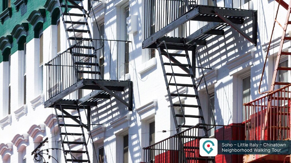 A building with fire escapes and a red brick wall. 1