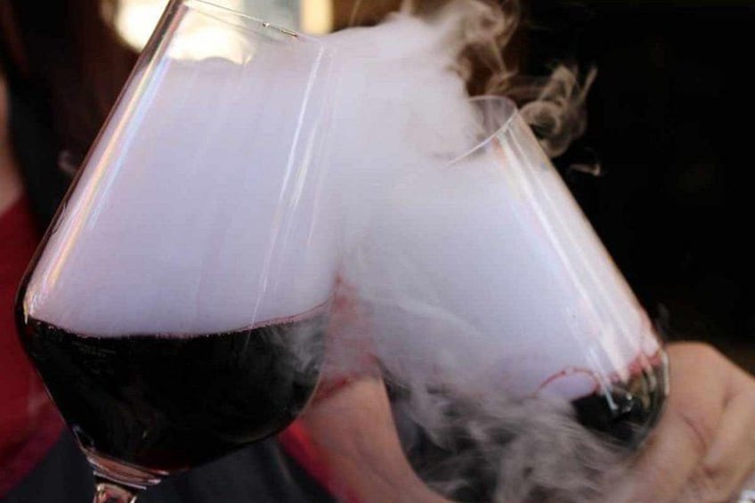 A glass of red wine with a foamy head. 3