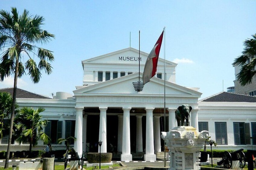 Ein Museum mit neoklassizistischer Fassade, Palmen und einer Flagge. 2