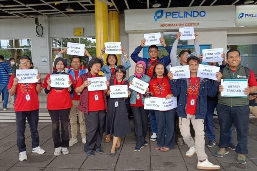 Un grupo de personas sosteniendo carteles frente a un edificio con un cartel que dice 'PELINDO INFORMATION CENTER'. 3