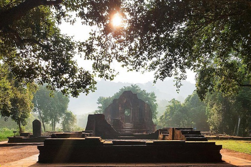 A historical site with ruins, surrounded by trees and a misty background. 4