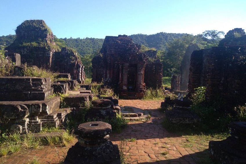 Ancient ruins with stone structures and a brick pathway. 5