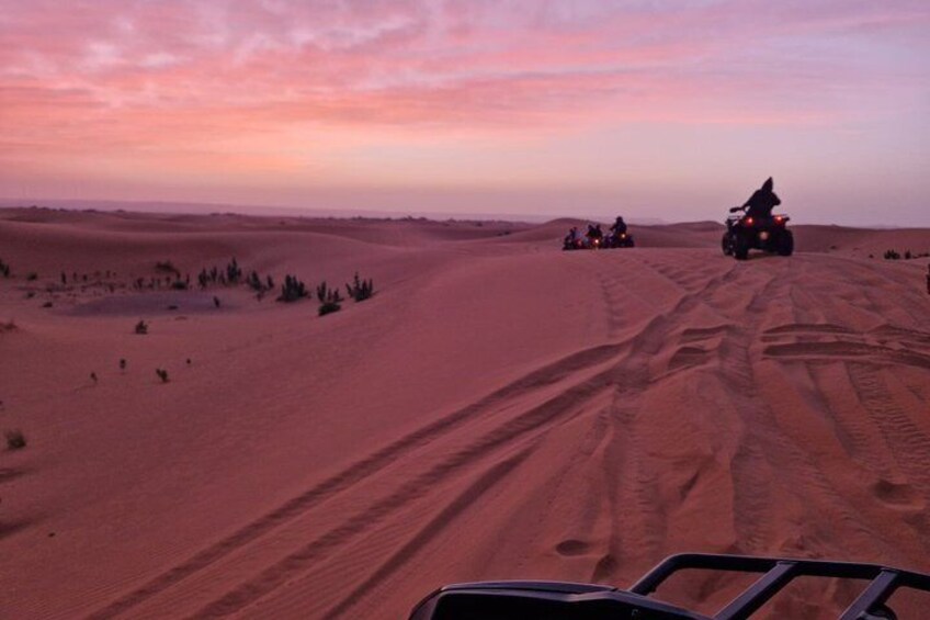 A desert landscape with sand dunes and off-road vehicles. 3