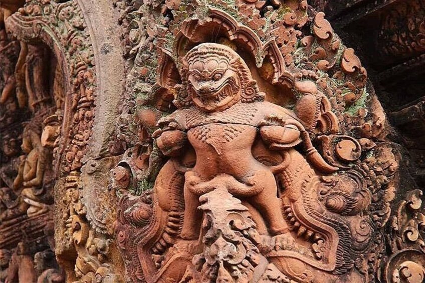 A detailed stone carving of a mythological creature with intricate patterns and figures. 5
