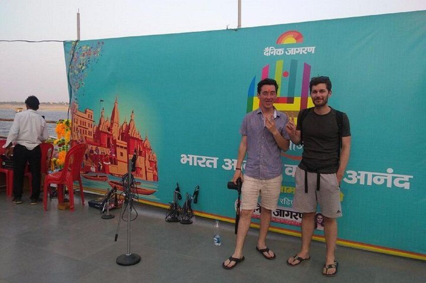Two men standing in front of a colorful backdrop with text and graphics. 4