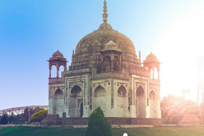 A large, ornate building with a dome and multiple arches, surrounded by a grassy area. 2