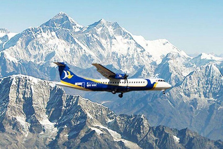 Ett flygplan som flyger över snötäckta berg. 3