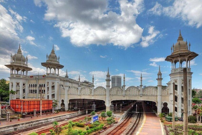 A grand building with domes and minarets, railway tracks, and a clear sky. 3