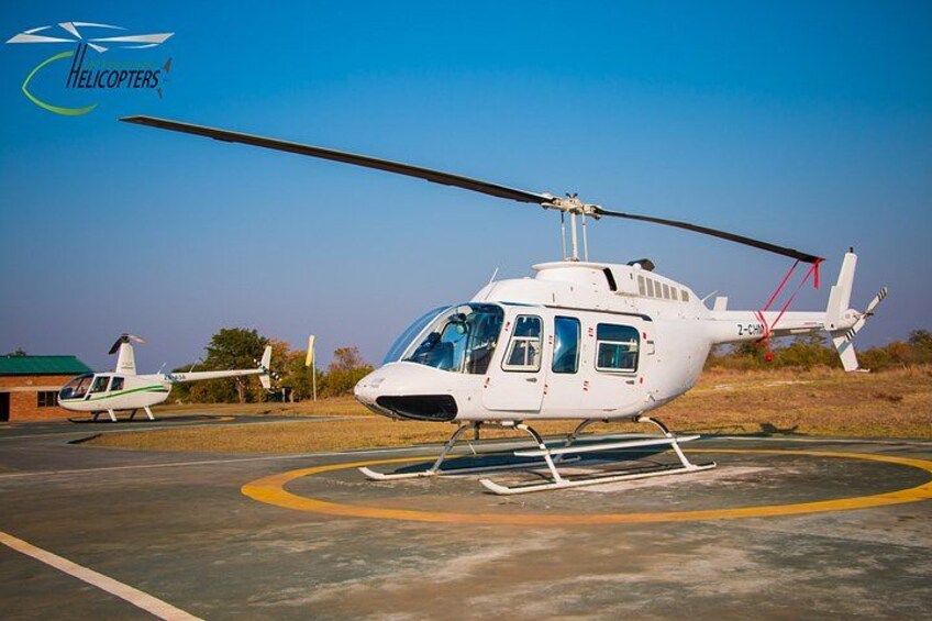 Un helicóptero blanco sobre una plataforma de tarmac con cielo despejado. 2