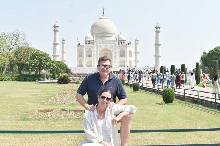 A couple posing in front of the Taj Mahal with the monument in the background. 4