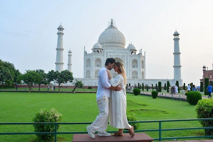 A couple embracing in front of the Taj Mahal. 4