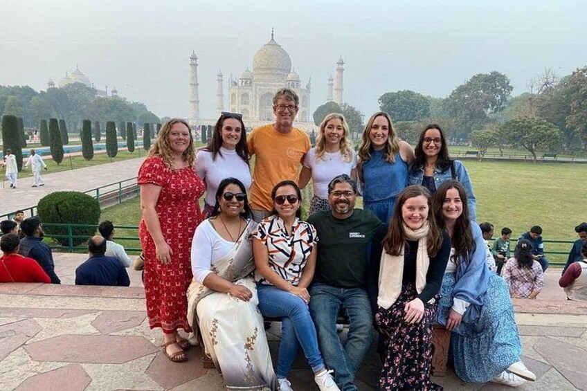 A group of people posing in front of the Taj Mahal. 2