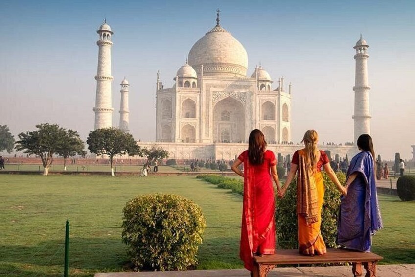 The Taj Mahal with three people standing in the foreground. 1