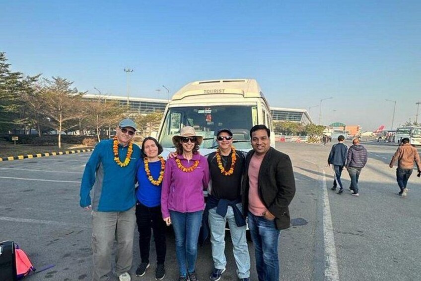 A group of people standing in a parking lot with a bus labeled 'TOURIST' in the background. 5