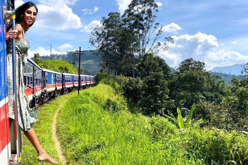 A train on a track, surrounded by lush greenery and hills. 2