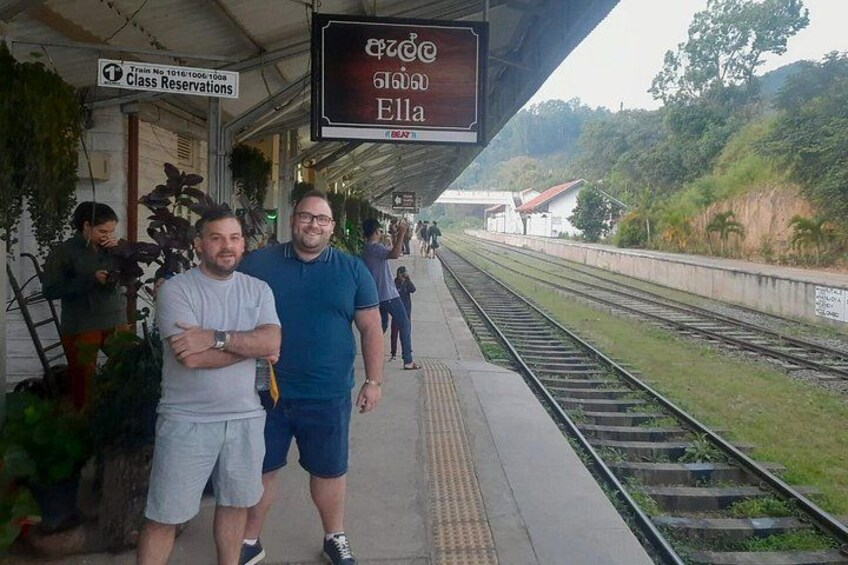 A train station platform with a sign for 'Train No 1016-1008 Class Reservations' and a sign with 'Ella' written on it. 4