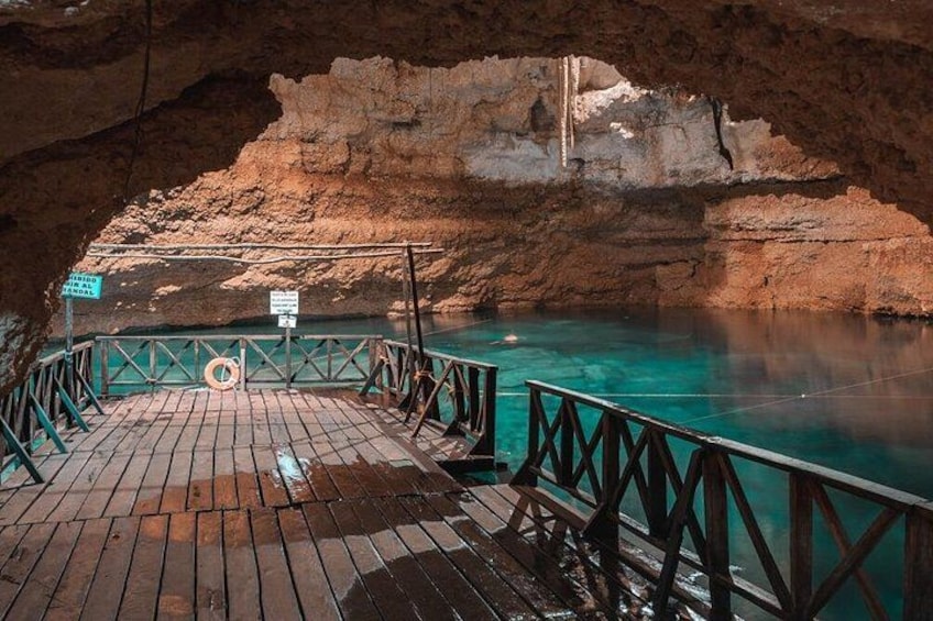 Une jetée en bois qui mène à une grotte aux eaux turquoise. 5