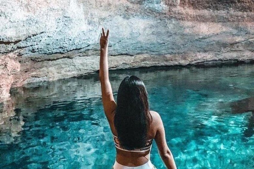 Une personne se tient debout dans une étendue d’eau claire, avec un mur rocheux en arrière-plan. 2