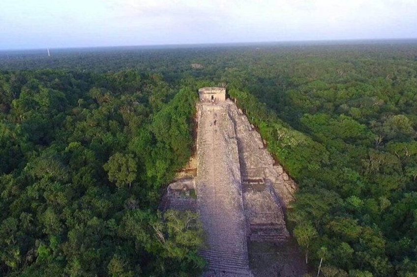 Une vaste pyramide antique, entourée d’une forêt dense. 1
