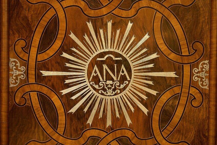 A wooden surface with a sunburst design and the letters 'ANA' in the center. 2