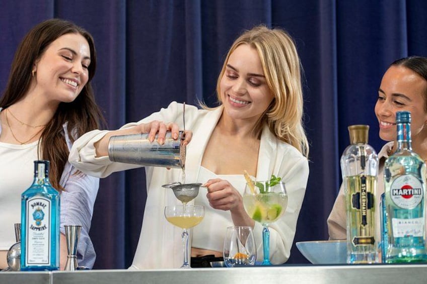 A bartender pouring a drink into a glass. 1