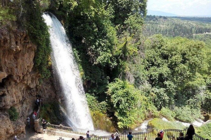 Una cascada se precipita por un risco rocoso rodeado de abundante vegetación. 2