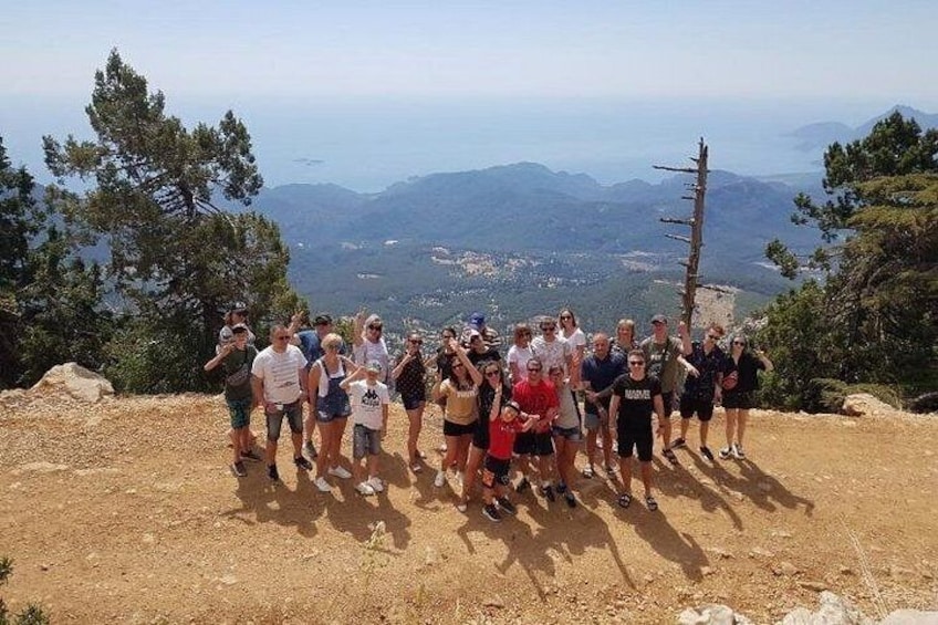 A group of people standing on a dirt path with a mountainous landscape in the background. 4
