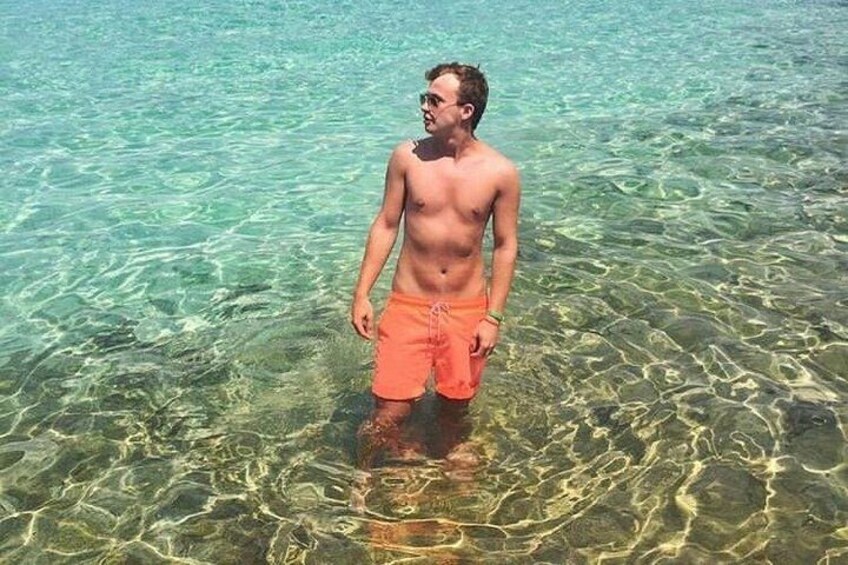 A man standing in clear shallow water. 3