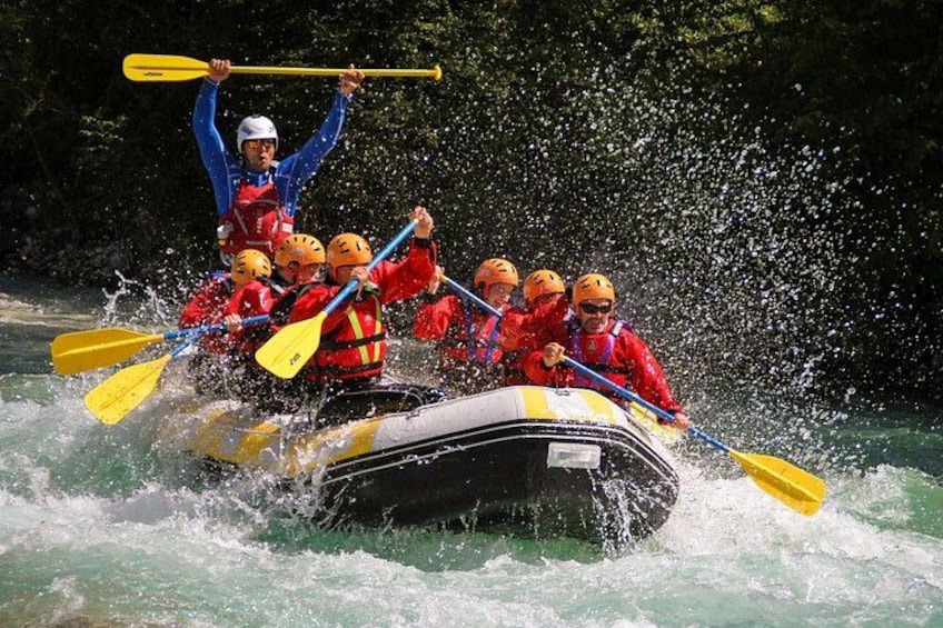 A group of people in a raft navigating a river, wearing life jackets and helmets. 1
