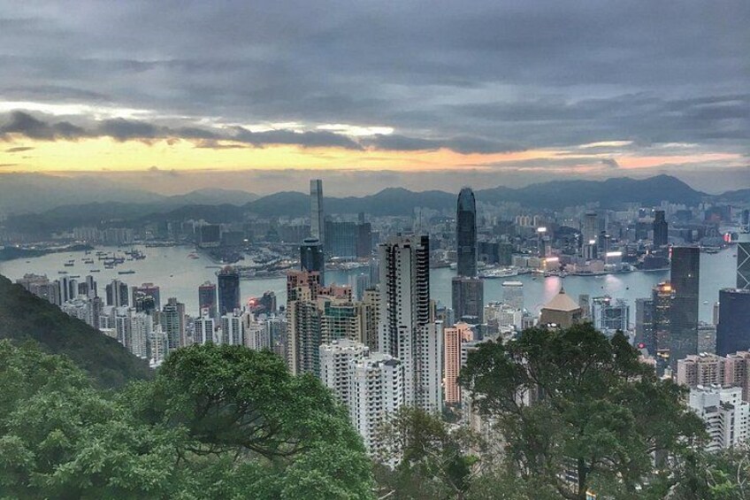 A cityscape with high-rise buildings, a body of water, and mountains in the background. 3