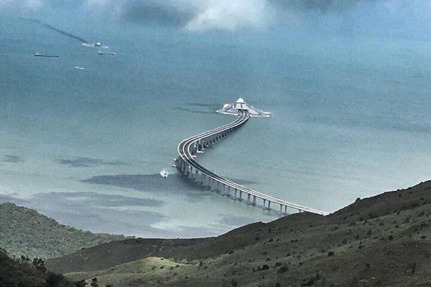 Een lange brug die door een bergachtig landschap slingert. 5