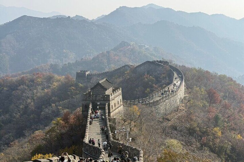The Great Wall of China winding through a mountainous landscape with autumn foliage. 5