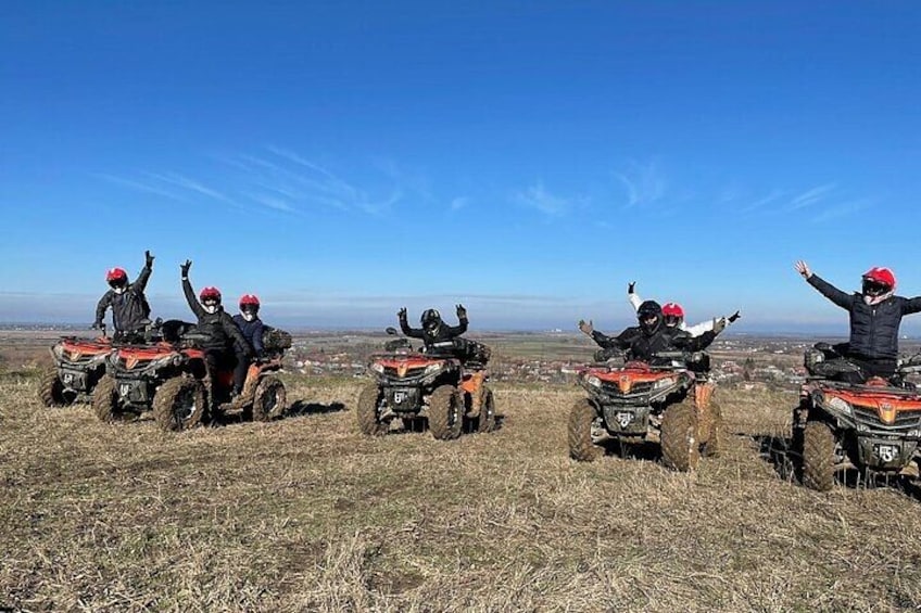 Cuatro personas en cuatrimotos en un campo cubierto de hierba, bajo un cielo despejado. 3