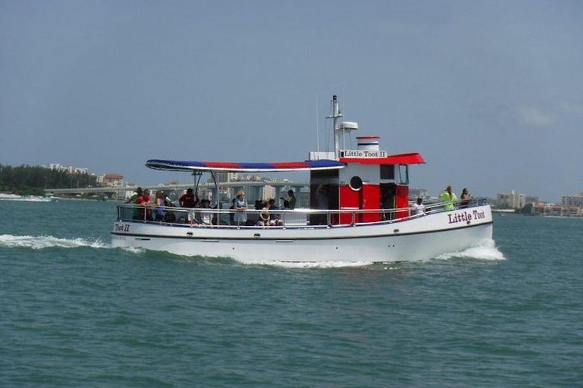Een boot genaamd 'Little Tool II' op het water met passagiers. 4